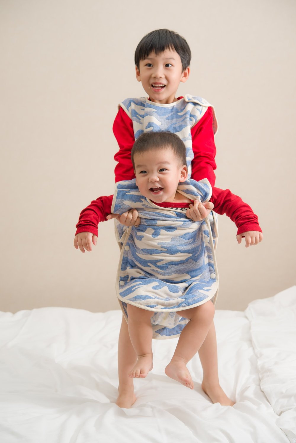 兩位孩子穿著藍色迷彩六重紗防踢被,呈現肩部與衣身穿著外觀