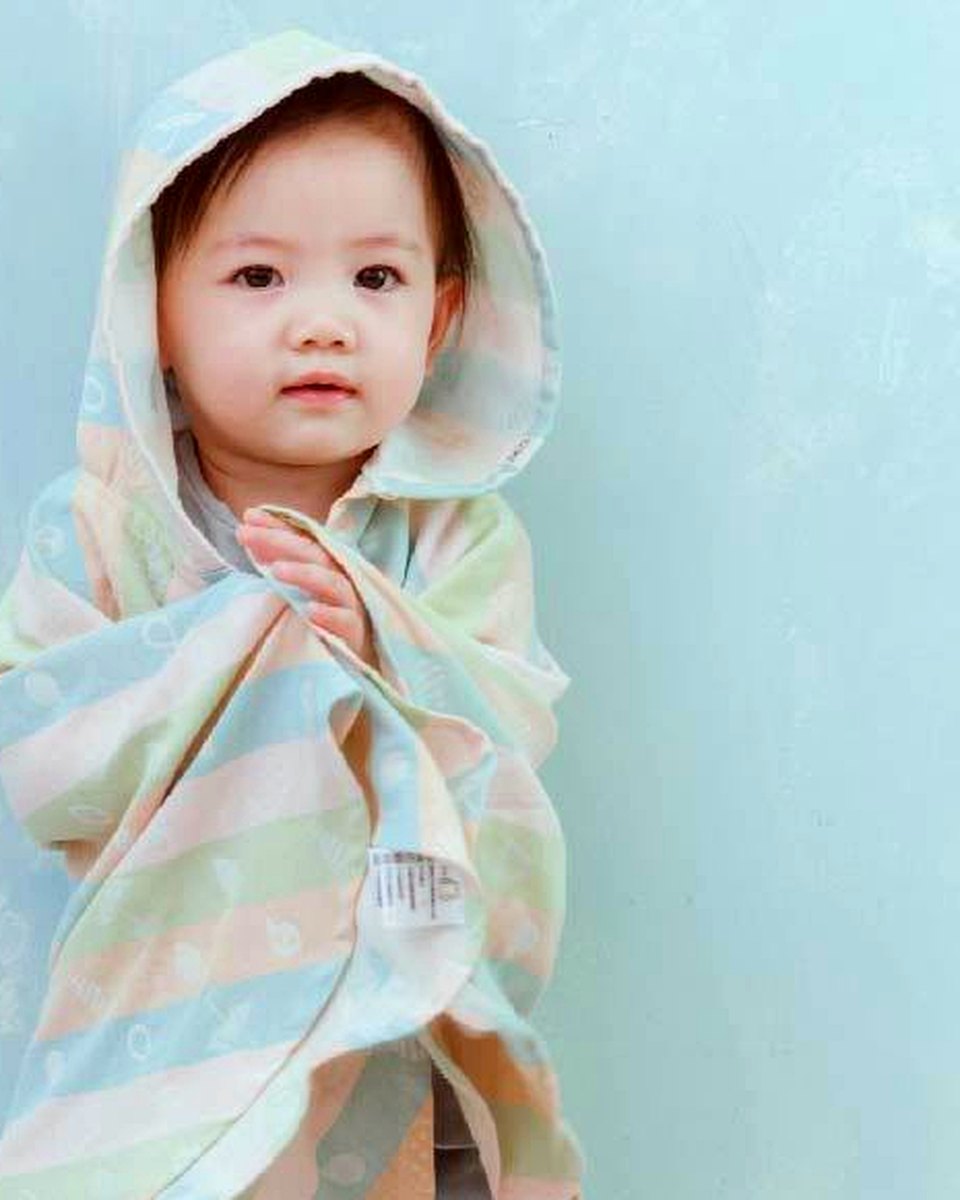 孩子披著 Lite 小斗篷連帽浴巾,可見帽子及胸前包覆